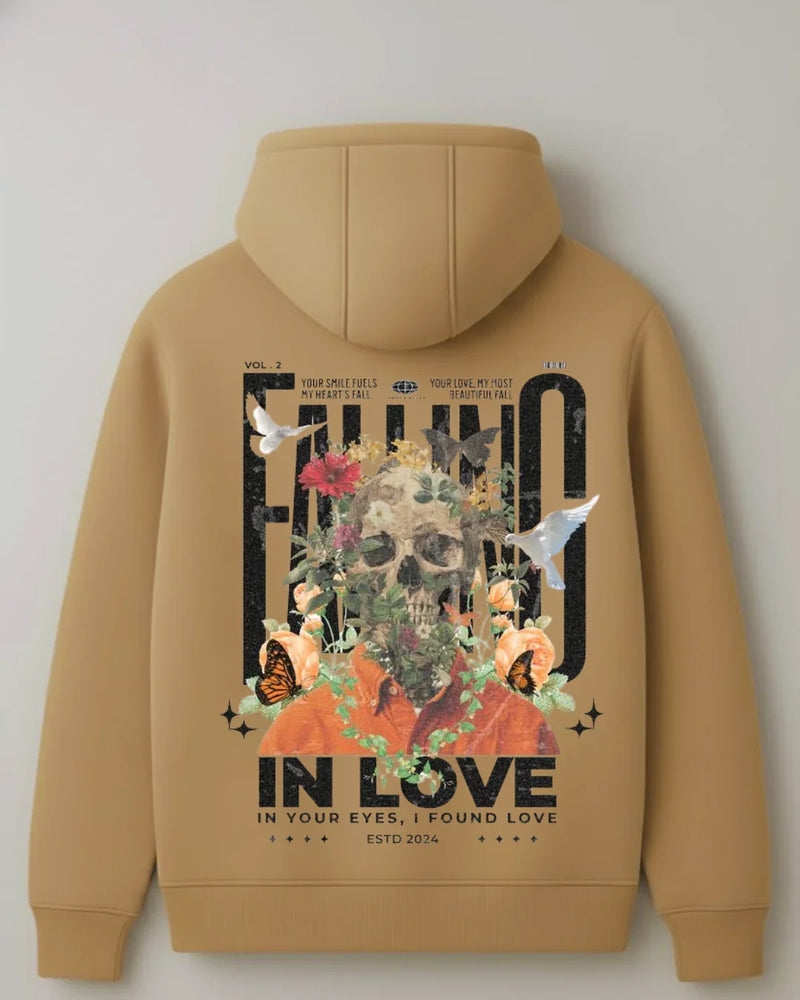Tan hoodie with skull, flowers, butterflies, and doves graphic, text reads 'FALL IN LOVE'.