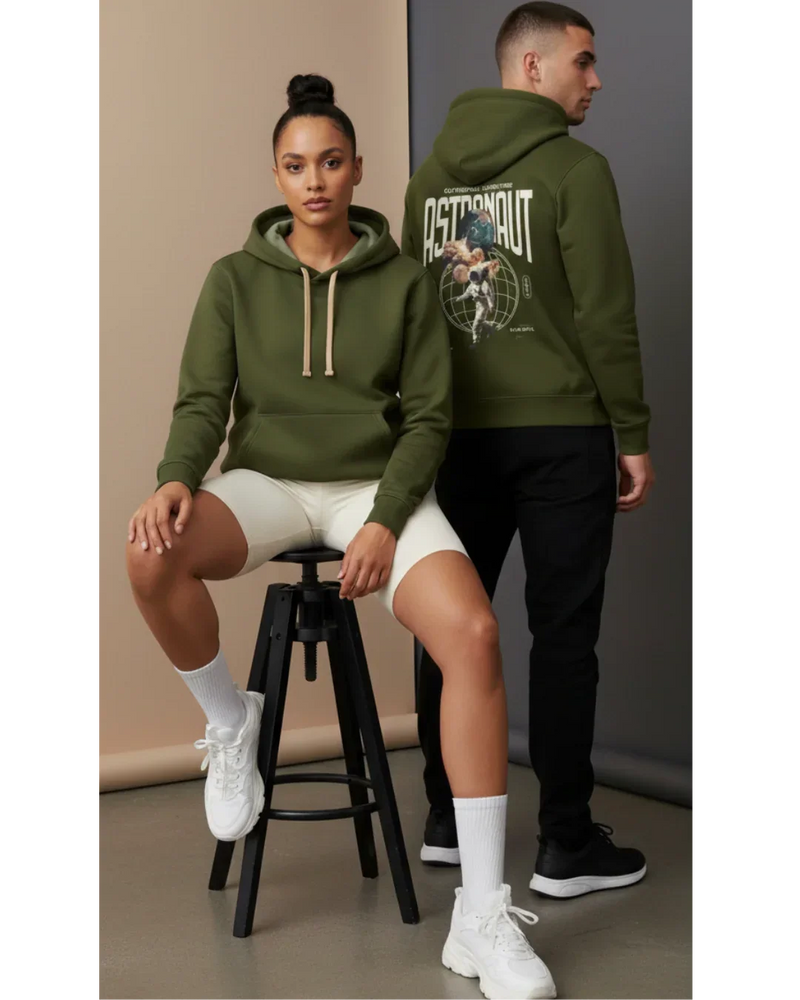 Two models in olive green astronaut graphic hoodies, casual athleisure studio setting