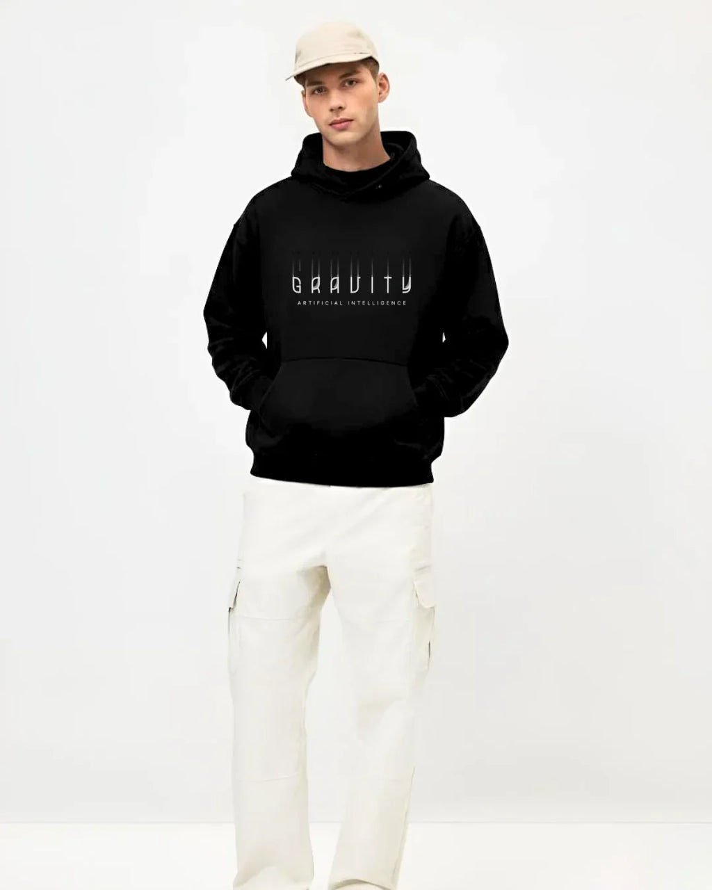 Man wearing black Gravity Artificial Intelligence hoodie, white pants, and beige cap in studio