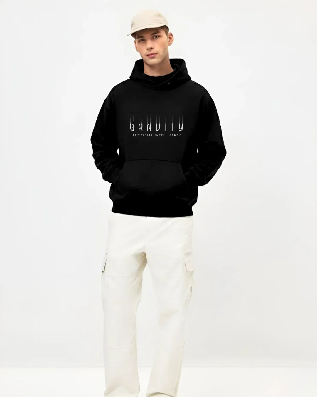 Man wearing black Gravity Artificial Intelligence hoodie, white pants, and beige cap in studio